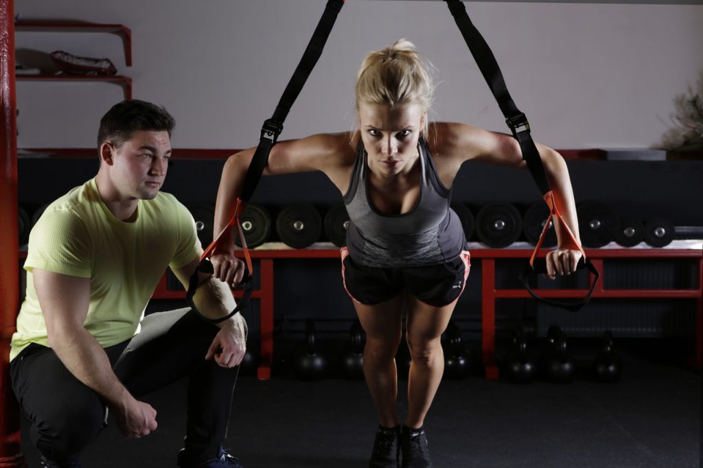 Women working out in a gym with a personal trainer