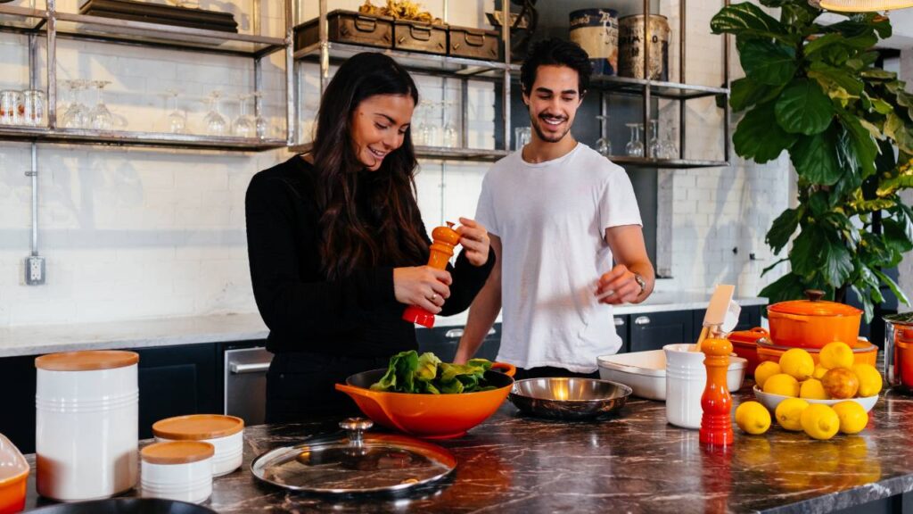 A man and a woman preparing fruit in a contemporary kitchen