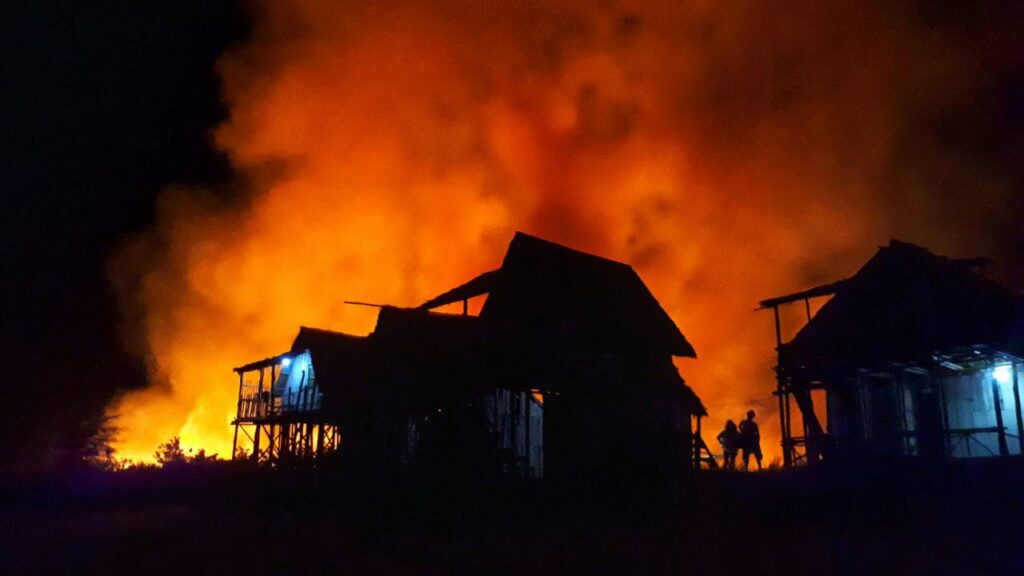 A large fire approaching a suburban residential area 